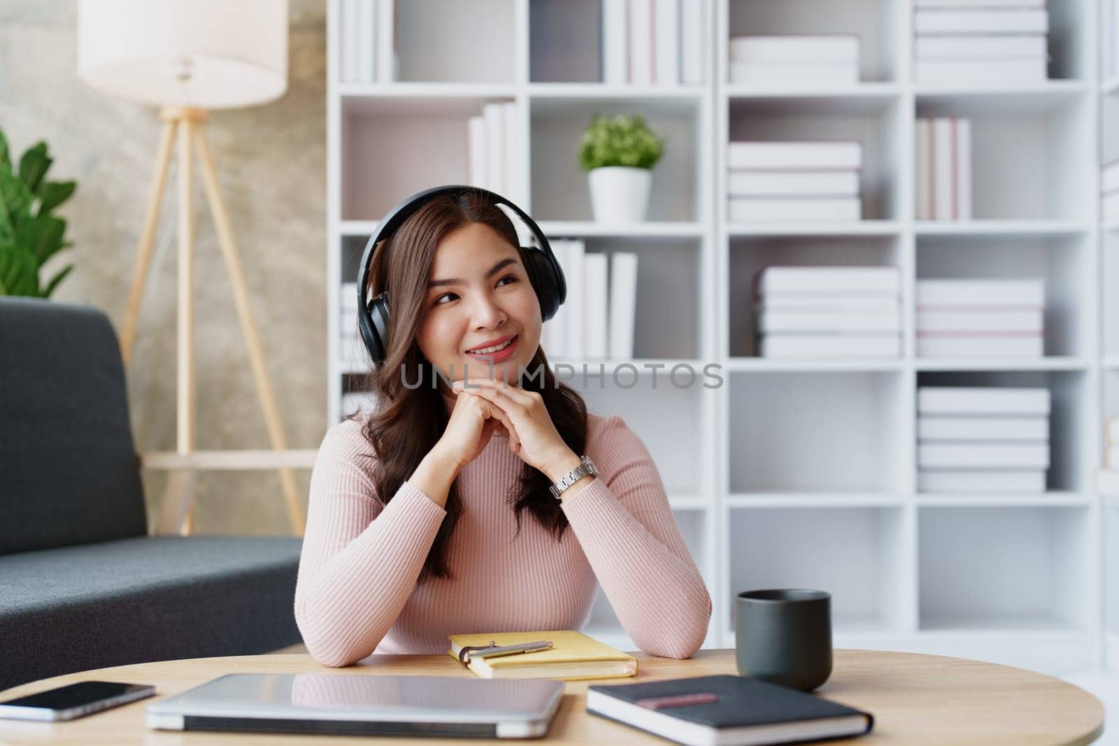 Woman relaxing wearing headphones and drinking coffee at home