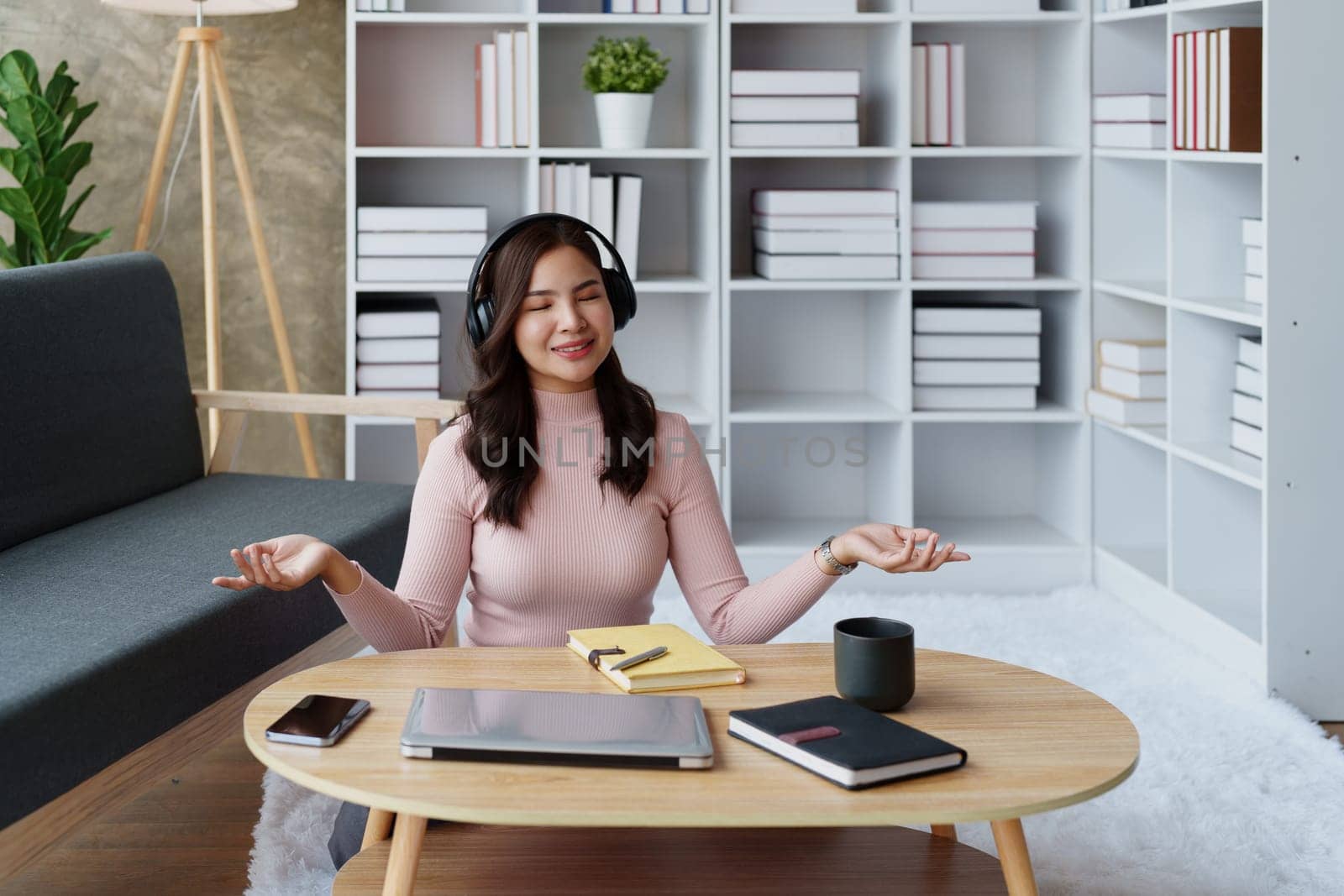 Woman relaxing, wearing headphones and meditating. by Manastrong