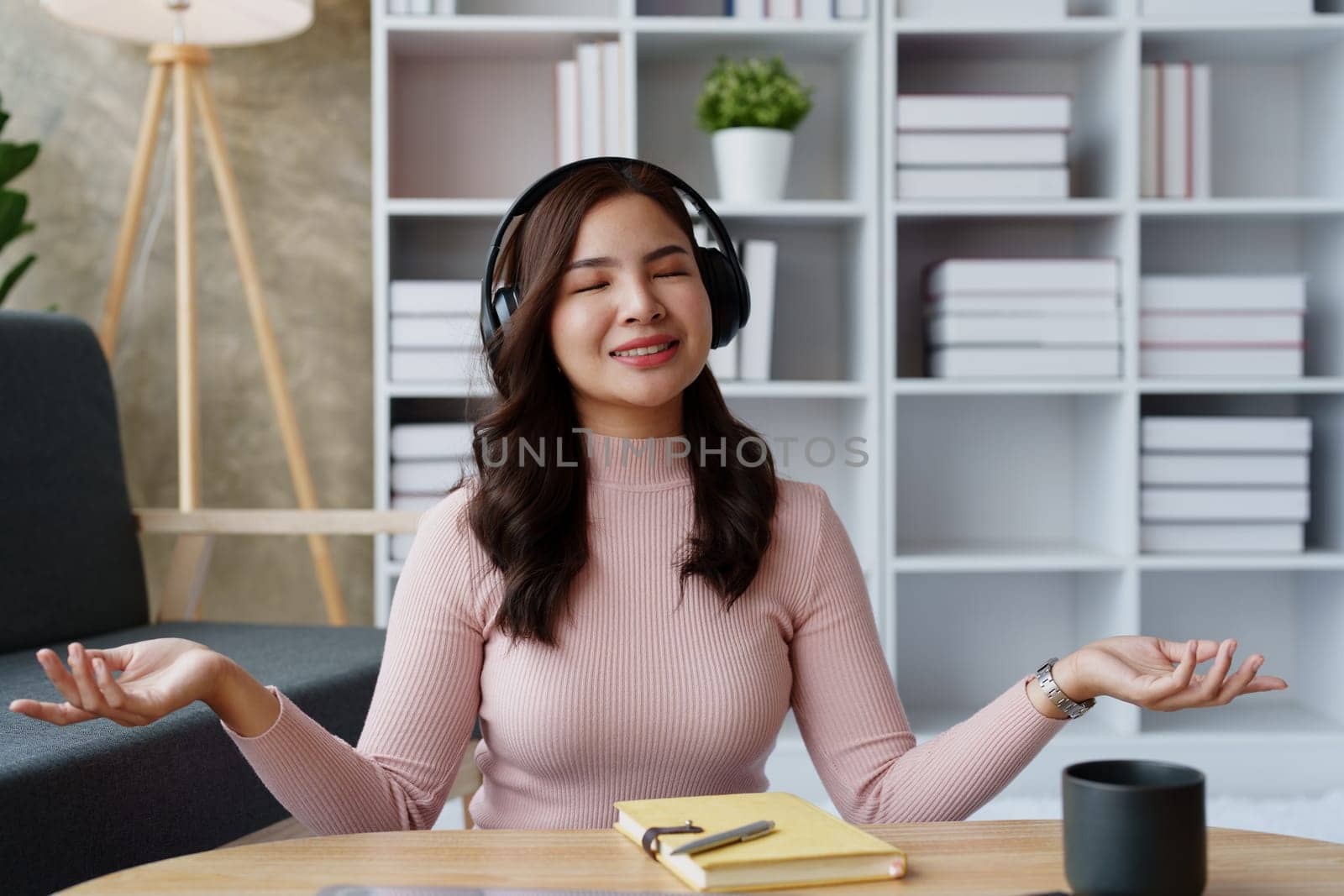 Woman relaxing, wearing headphones and meditating. by Manastrong