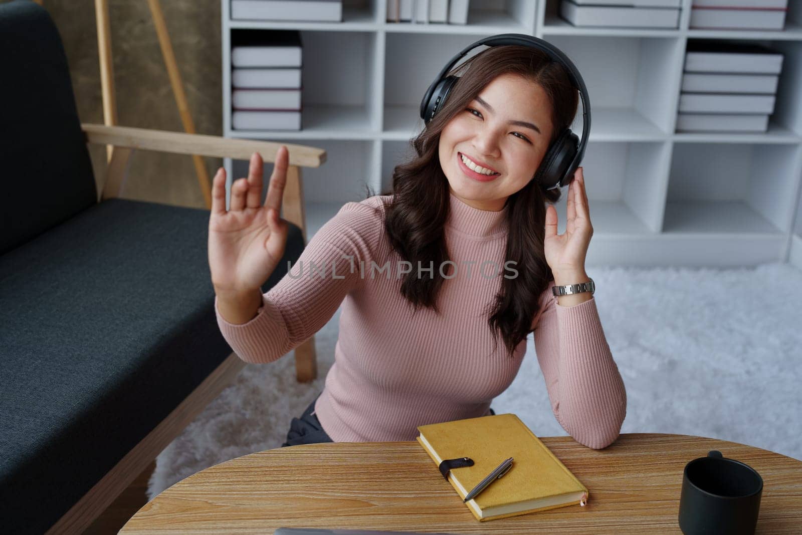 Woman relaxing wearing headphones listening to music in her house. by Manastrong