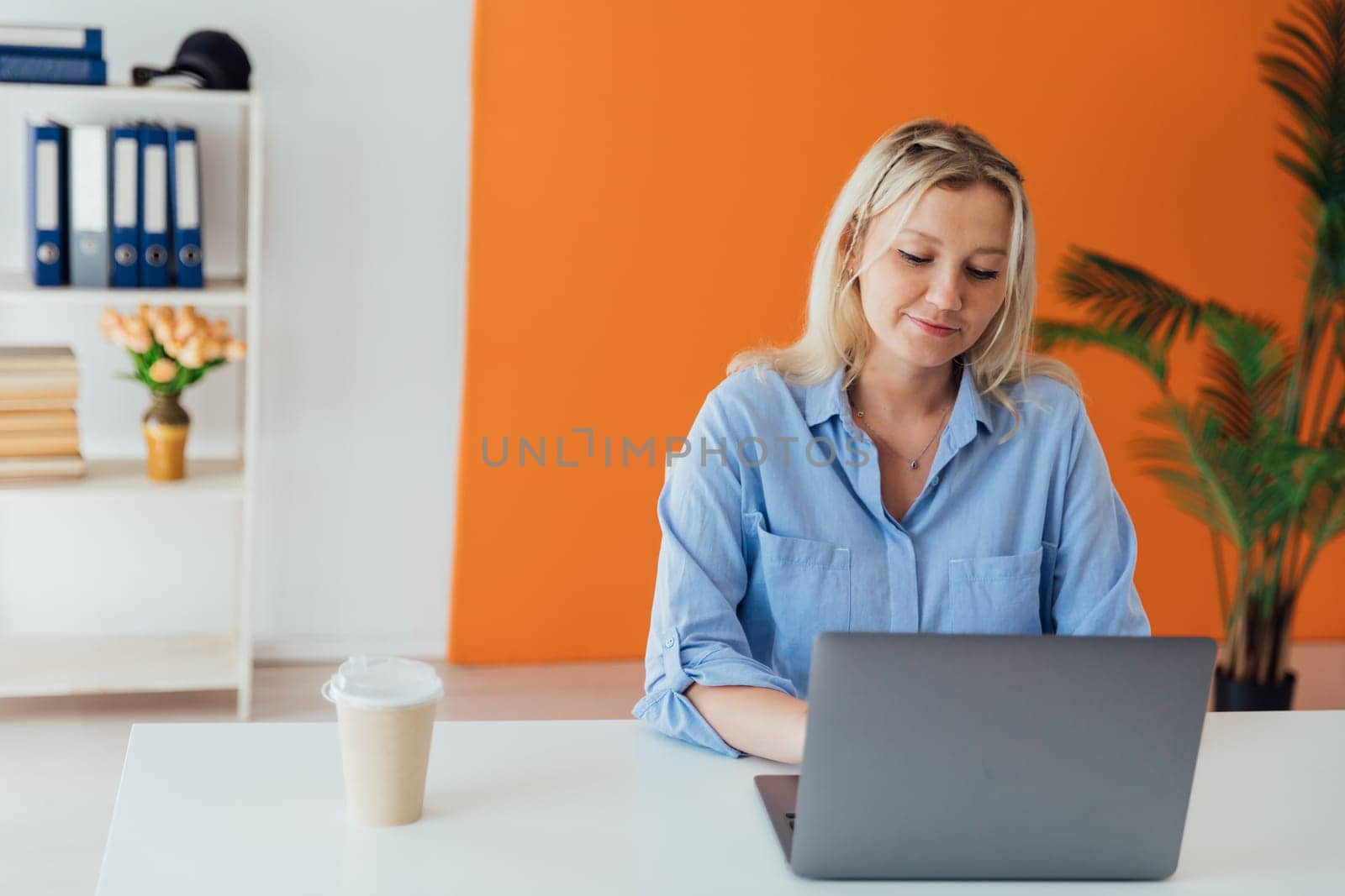 Business woman working on laptop at desk in office at home
