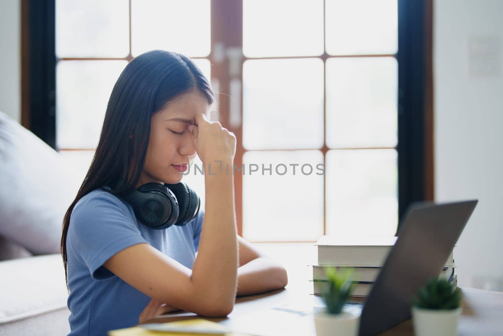 Studying online, beautiful Asian female student show symptoms burnout syndrome student studying online at home.