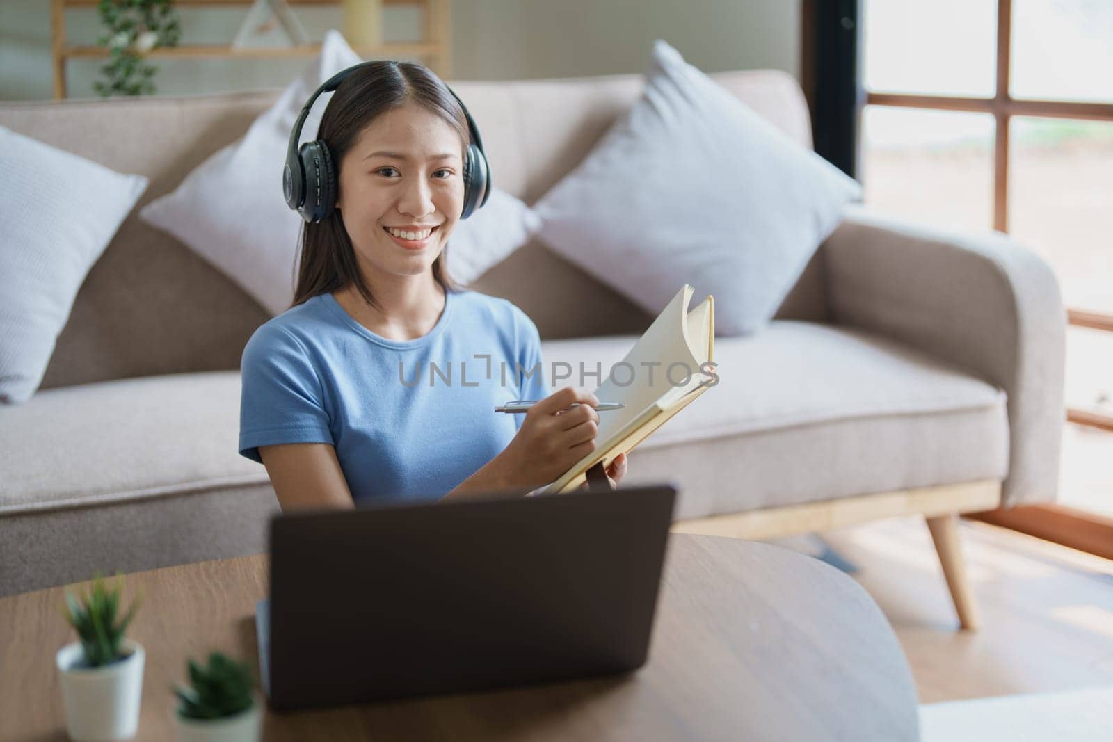 Studying online, beautiful Asian female student or student studying online at home by Manastrong