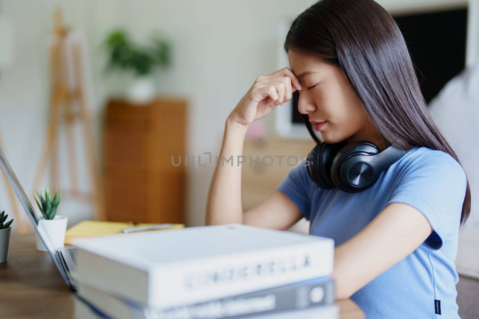 Studying online, beautiful Asian female student show symptoms burnout syndrome student studying online at home.