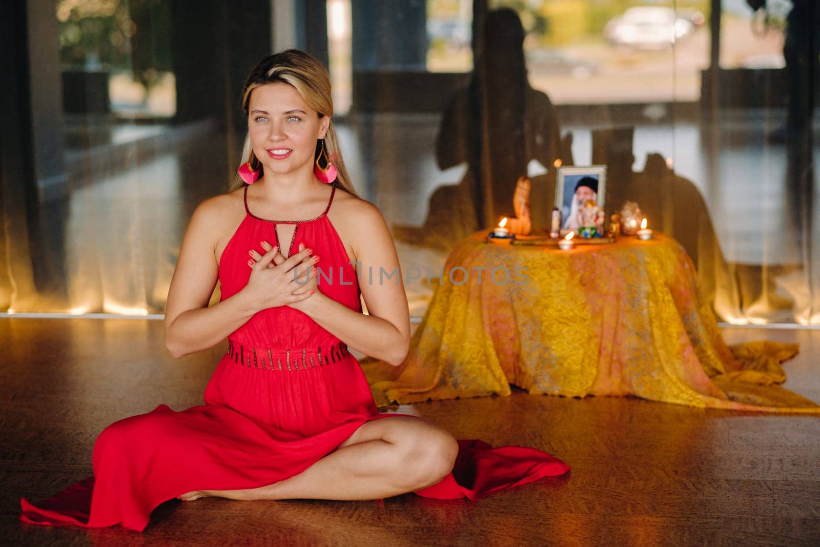 Meditation and concentration. a woman in a red dress sitting on the floor is practicing medicine indoors . Calm and relaxation by Lobachad