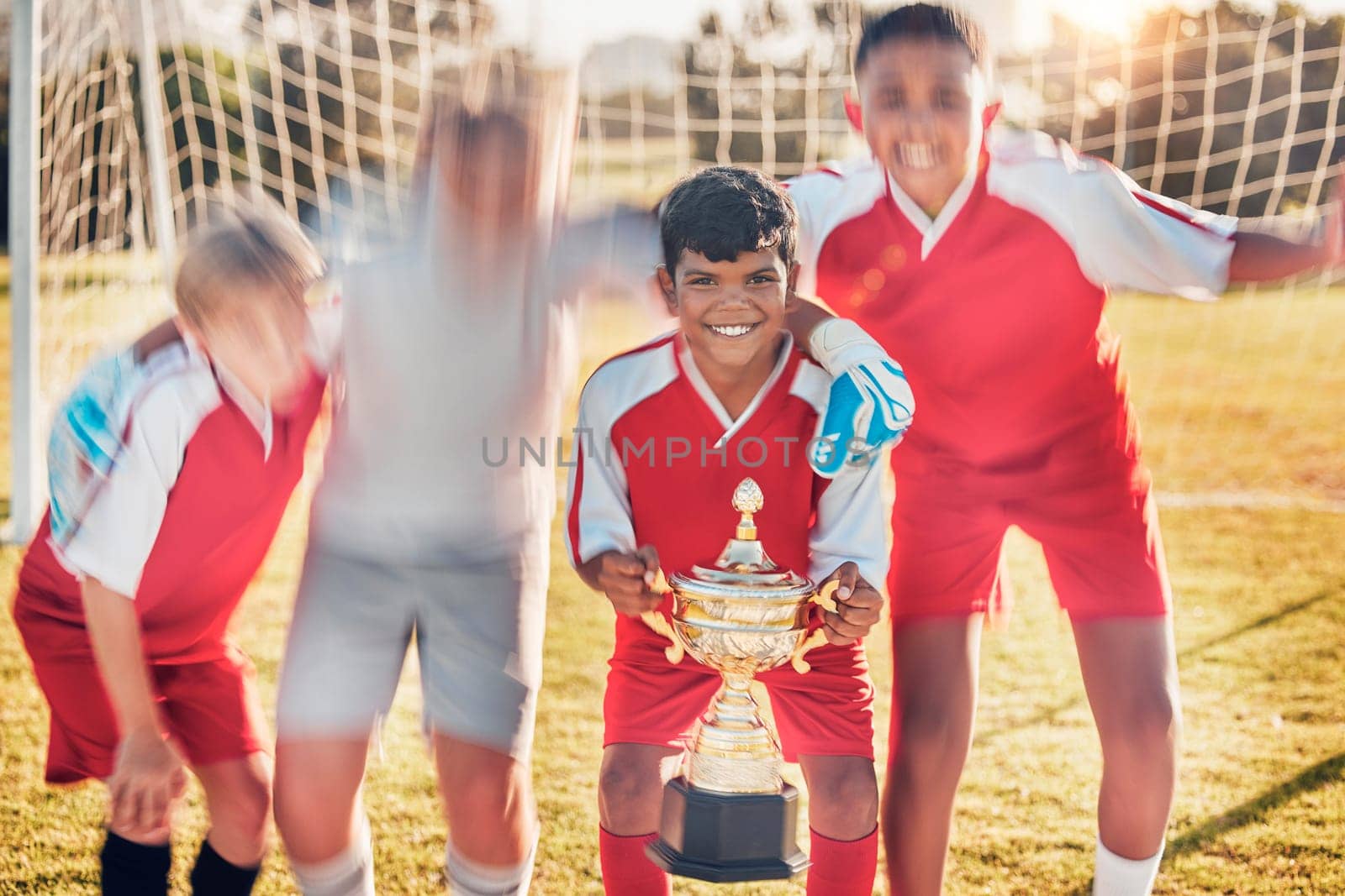 Trophy, soccer and team in celebration of success as winners of a sports award in a childrens youth tournament. Happy, goals and young soccer players celebrate winning a kids football championship by YuriArcurs
