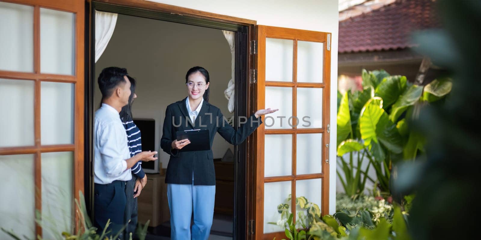 Couple lover with real estate agent visiting house for sale. husband and wife who plan property investment looking at lovely modern spacious home.