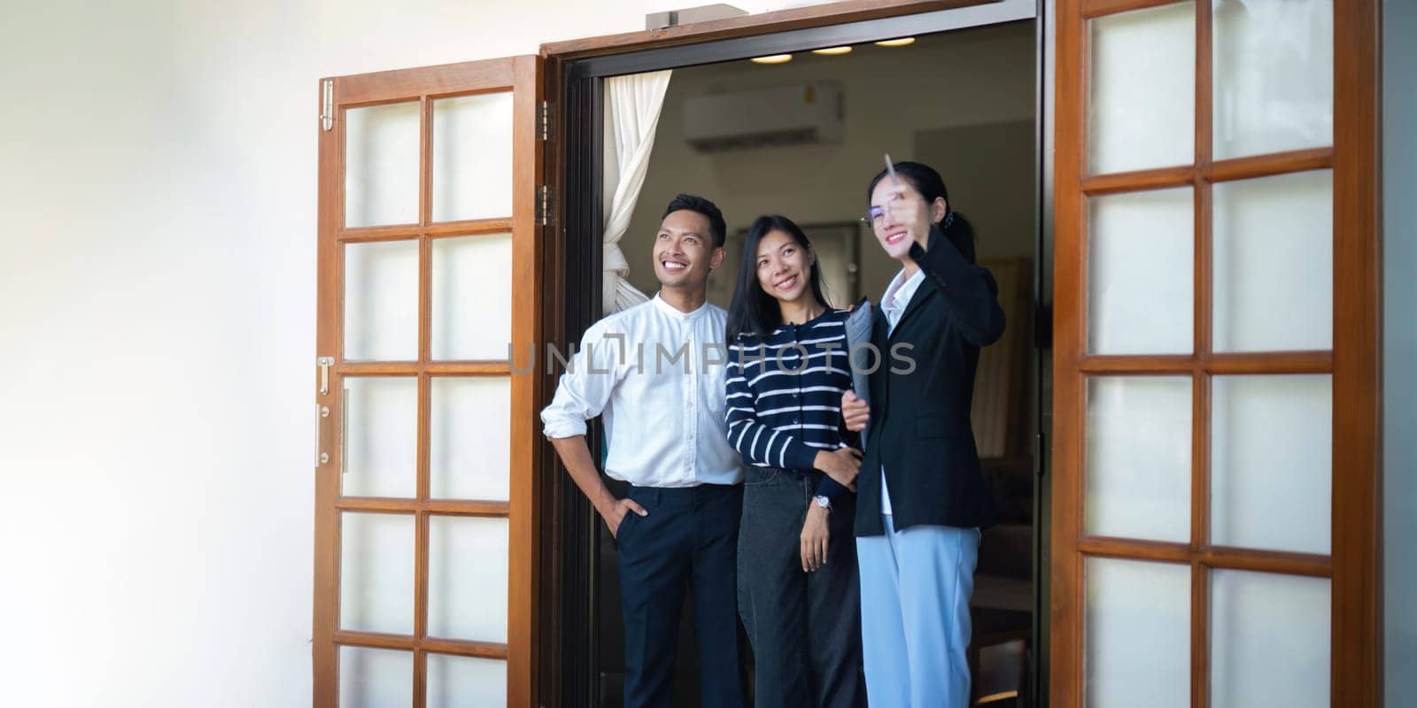 Couple lover with real estate agent visiting house for sale. husband and wife who plan property investment looking at lovely modern spacious home.