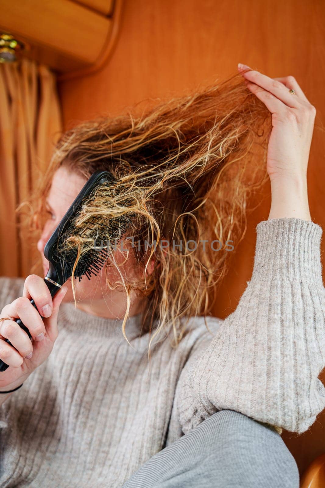 Young Girl Combing Extremely Tangled Hair with Patience and Care by PhotoTime