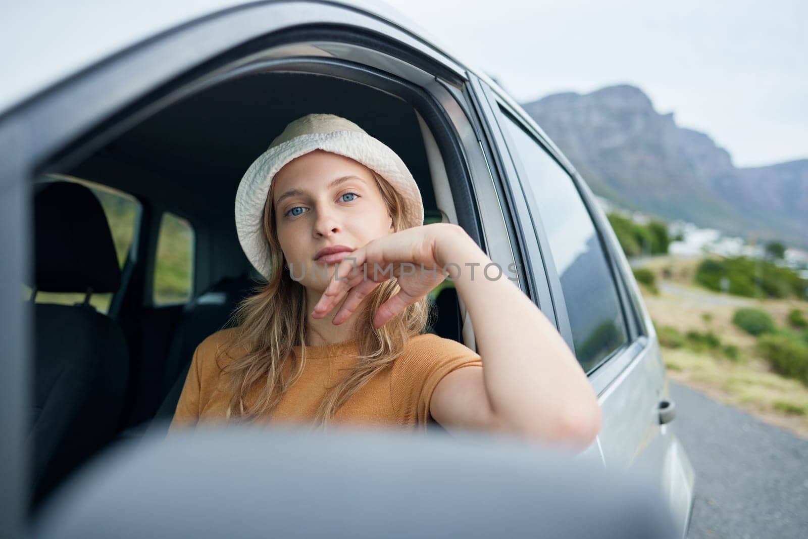 Travel, adventure and woman in transportation while on roadtrip with mountain in background during summer vacation. Young, in trendy fashion and portrait, calm and relax in nature while outdoors