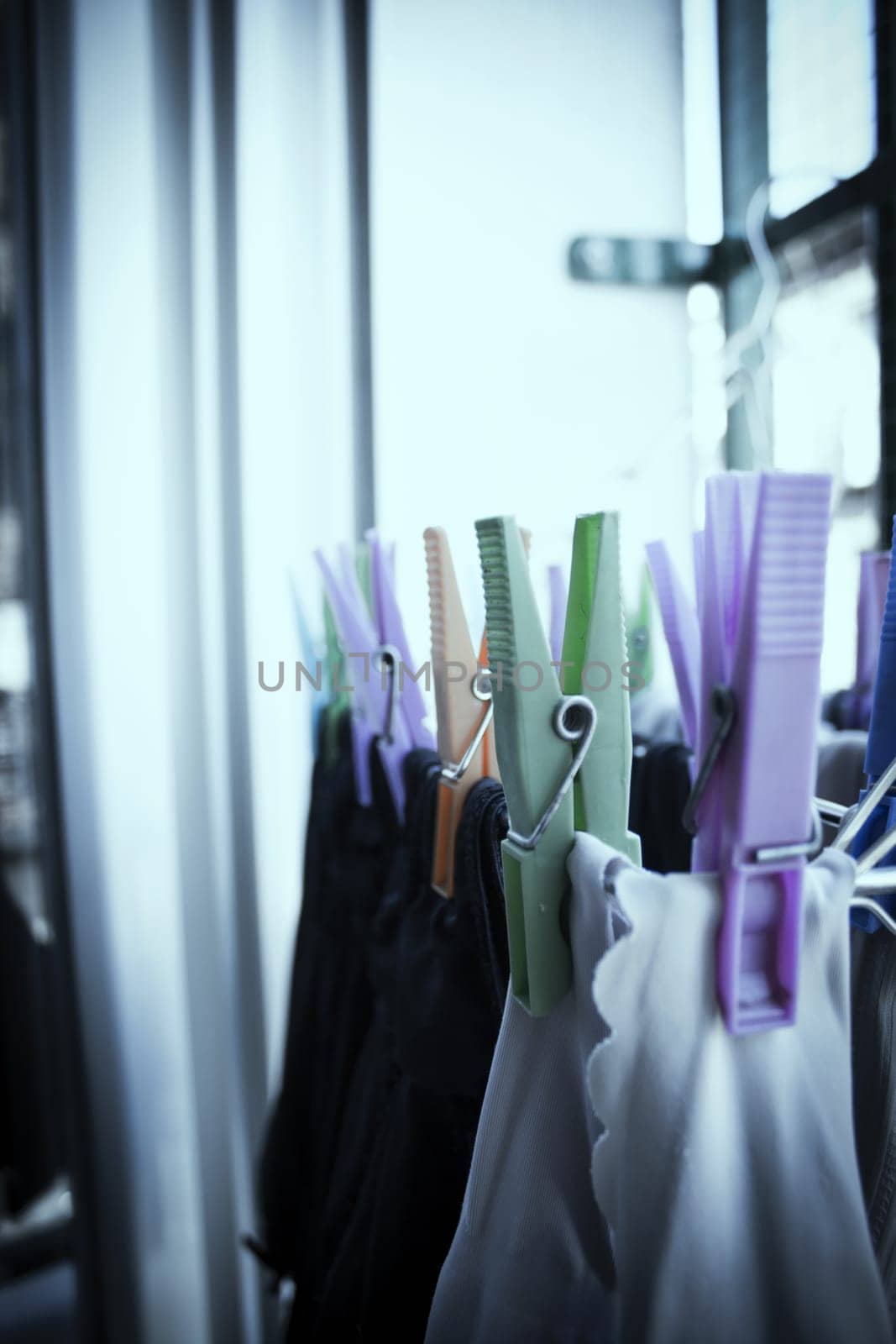 Clothespins holding clothes on clothesline. Various colors. No people