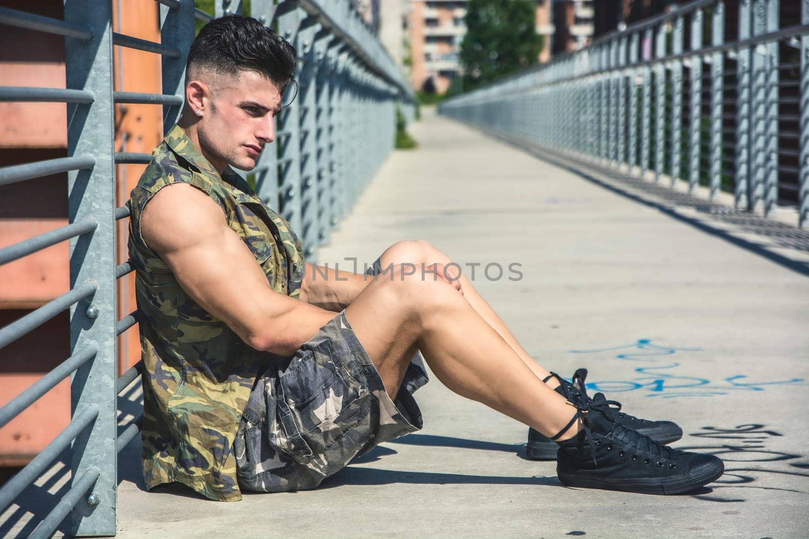A man sitting on a bridge with his legs crossed