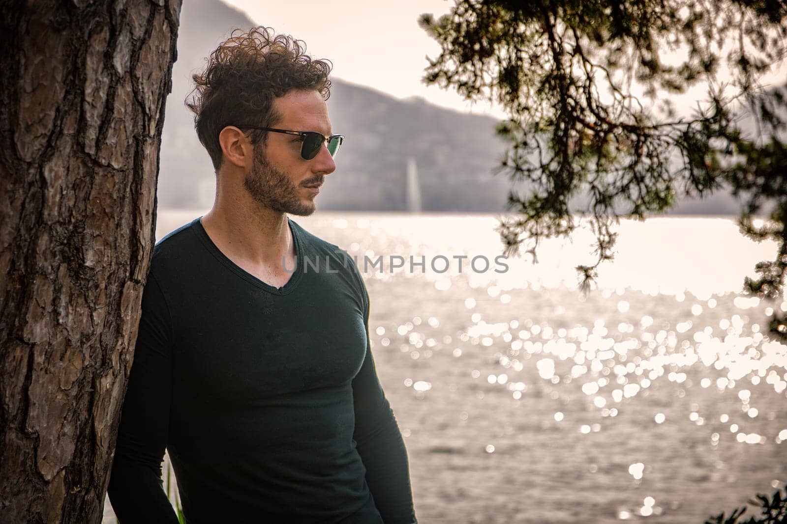 A Serene Encounter: A Handsome Man Contemplating Nature's Beauty by the Water's Edge by artofphoto