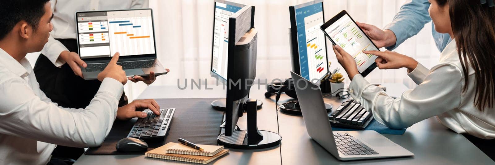 Project management team coordinating and update project planned schedule on computer using Gantt chart software in office. Business people planning time and deadline for company task. Trailblazing