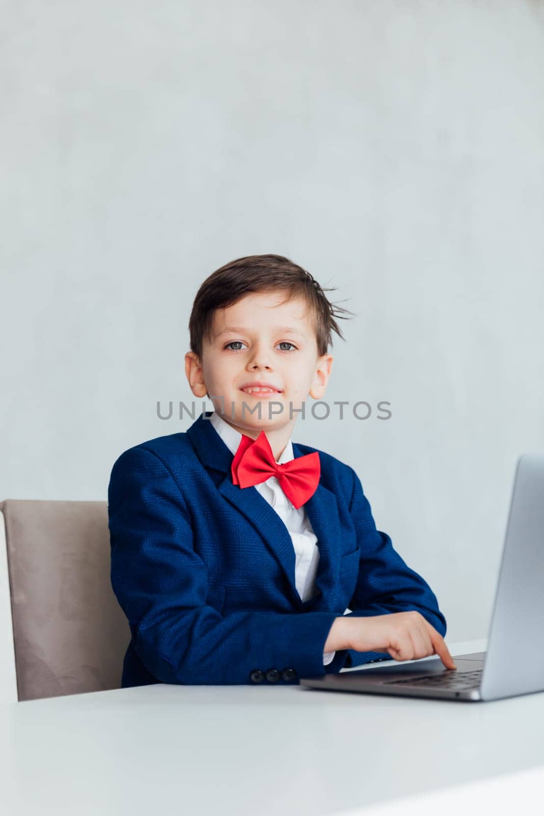 education IT knowledge child sitting at a laptop at school by Simakov