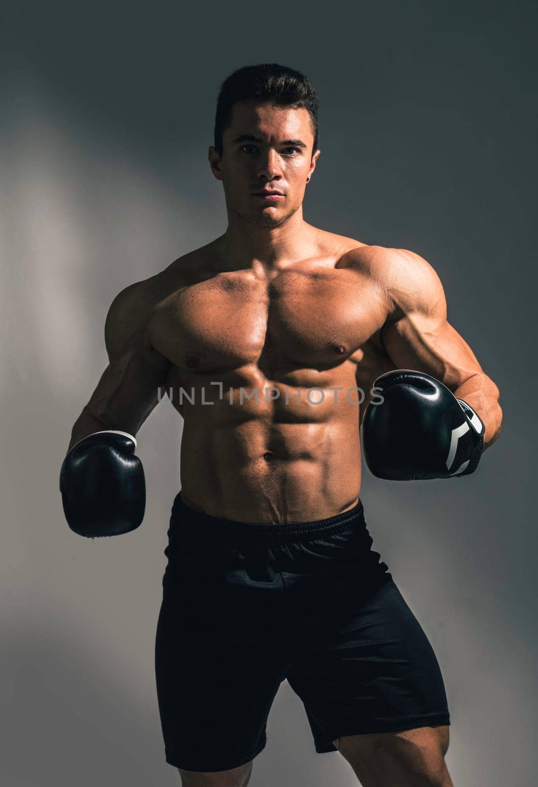 A man with no shirt and boxing gloves by artofphoto