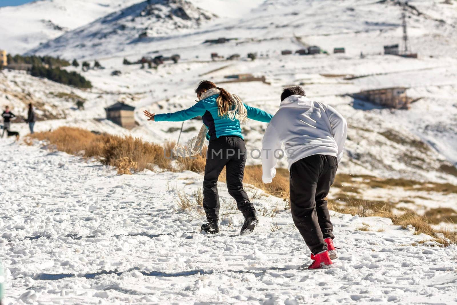 Icy adventures await! A Latino family revels in the snowy hills of Sierra Nevada, Granada, indulging in frosty fun