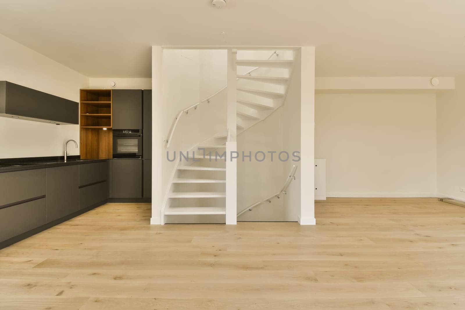 a spiral staircase in a kitchen leading to a white by casamedia