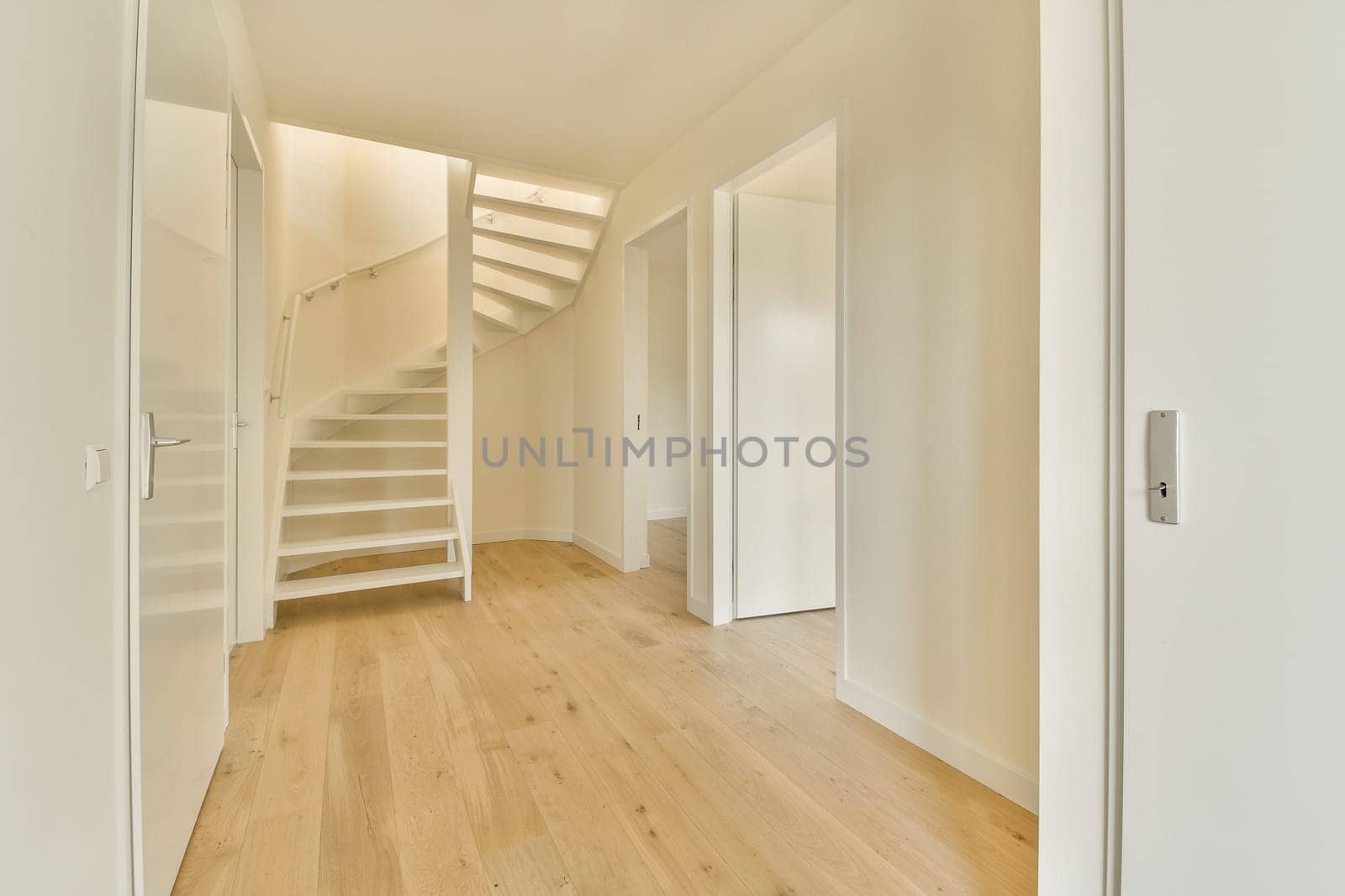 a room with a staircase and a white door by casamedia