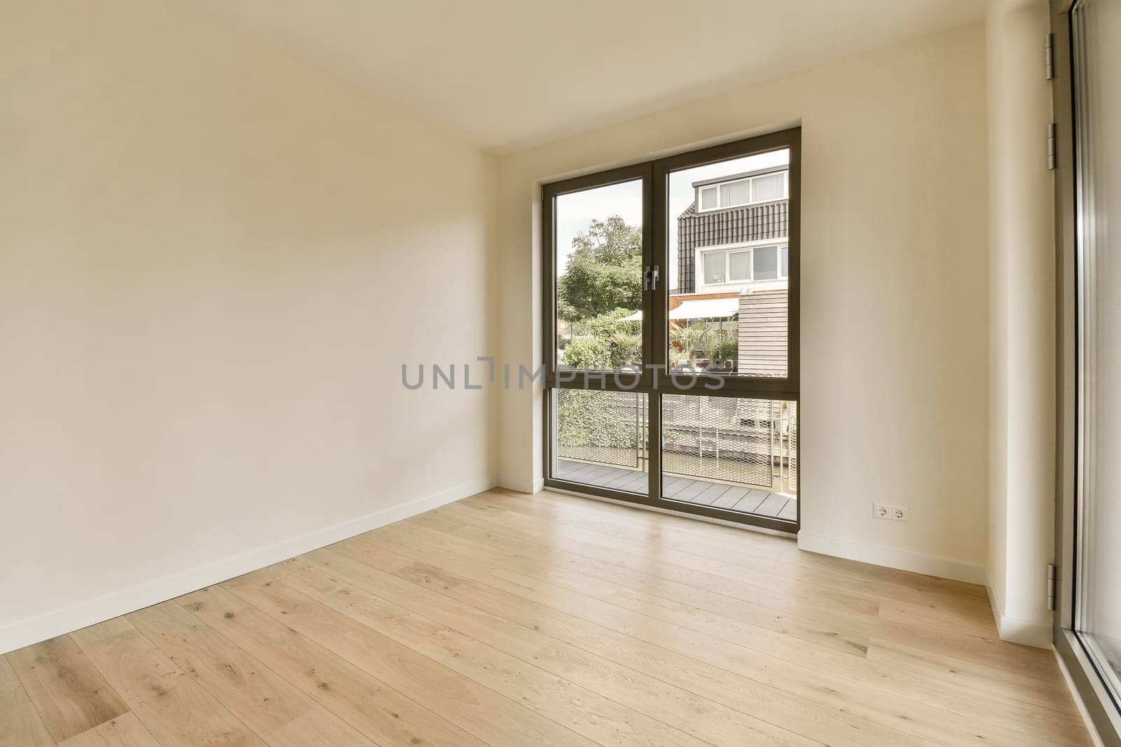 a living room with a large window and wooden floors by casamedia