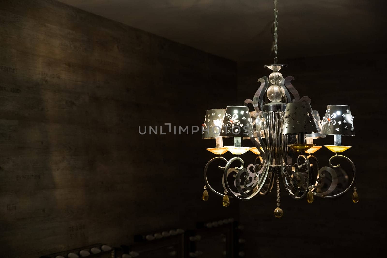 Close-up of antique chandelier with big yellow lightbulbs.