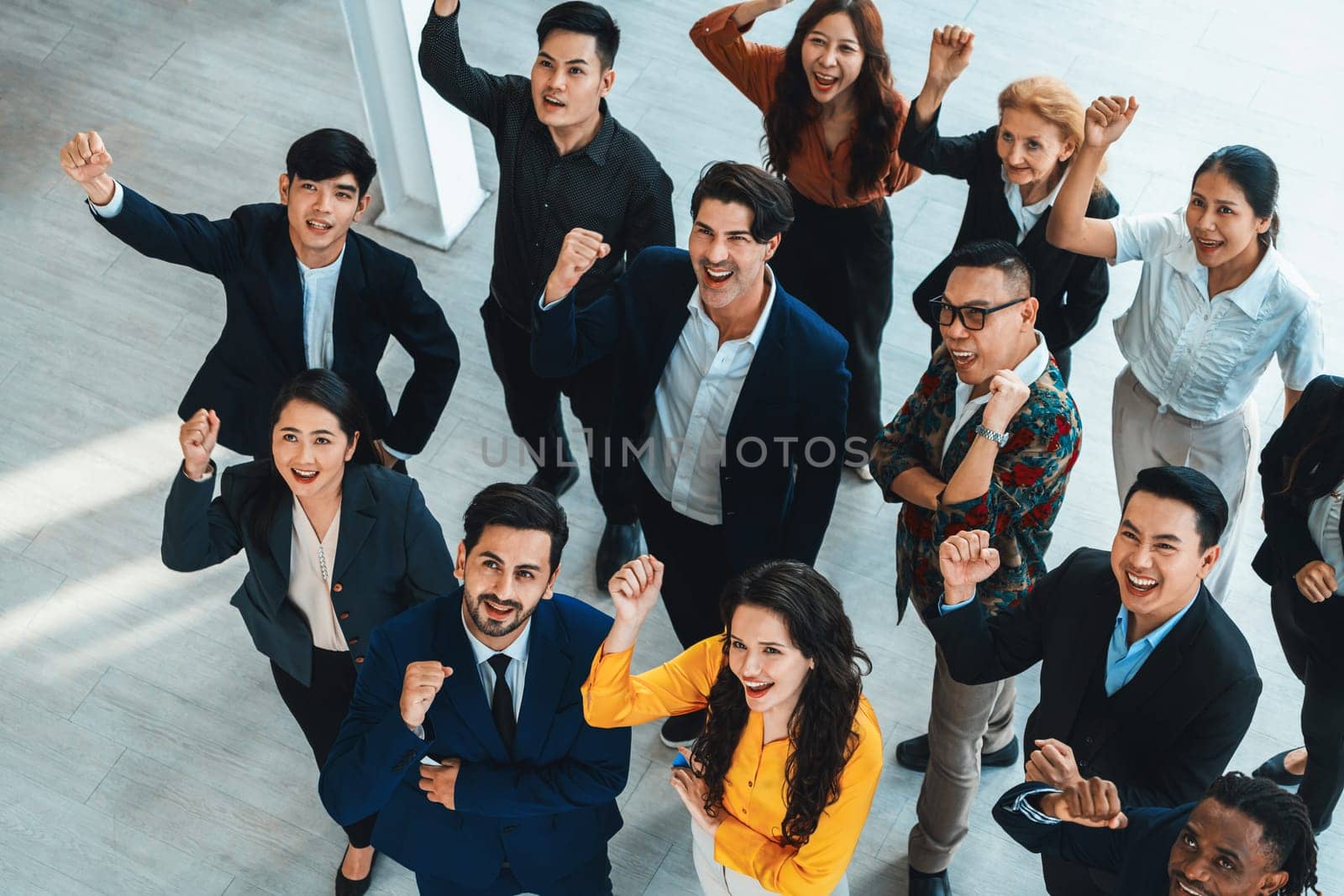 Happy diverse business people celebrating their success project.Top view. Group of successful energetic employees cheer up gratefully while looking at sky with white background. Intellectual.