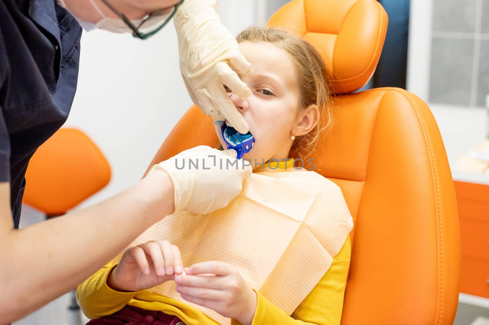 The orthodontist prepares a special paste for making an impression of the patient's teeth.