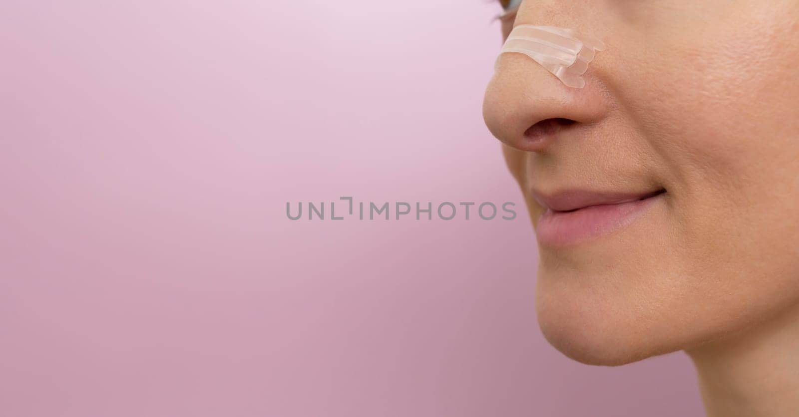 Mockup Closeup Nasal Strip on Female Nose on Pink Background. Stop Drug-Free Snoring Solution. Copy Space For Text. Adhesive Bandage for Better Breathing High quality photo