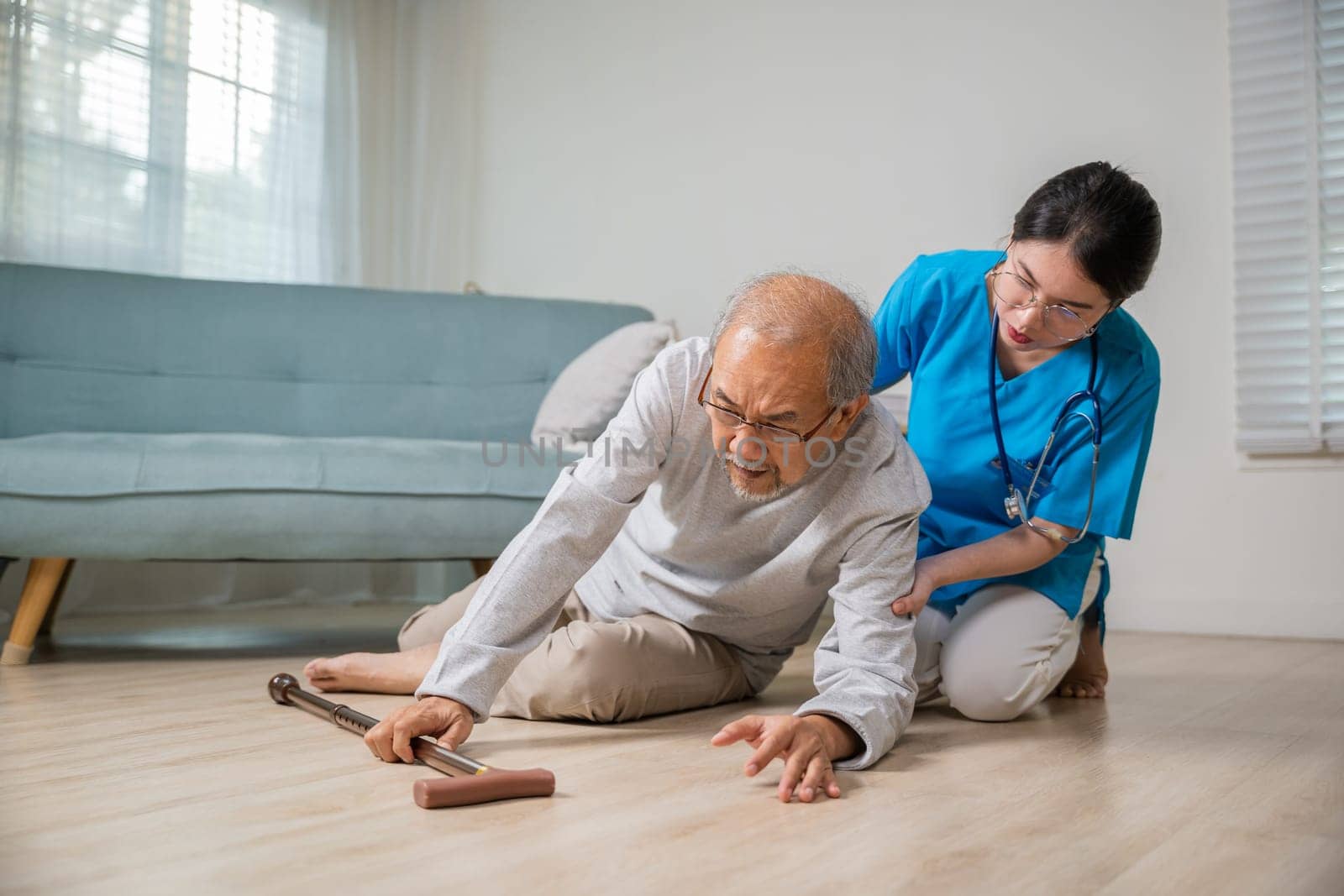 Asian older senior man falling down on lying floor and woman nurse came to help support, Disabled elderly old man patient fall down and caring young assistant at nursing home