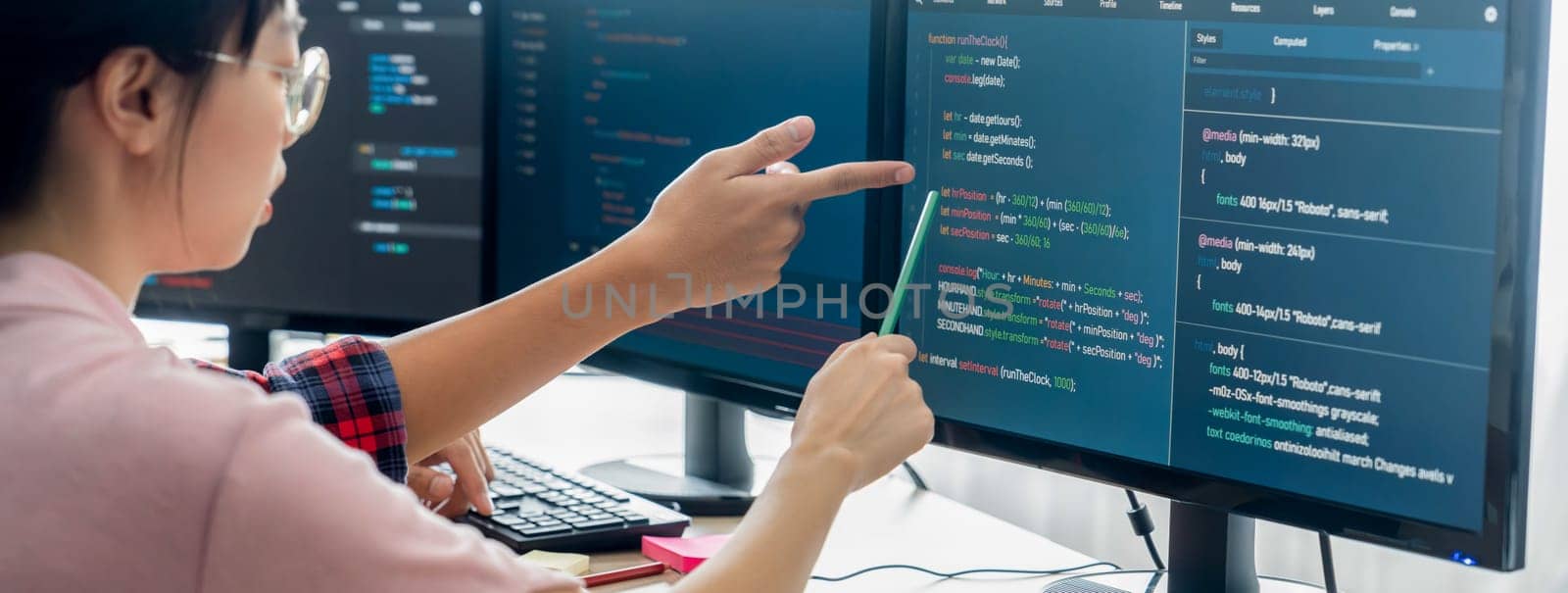 Female programer explain while pointing code displayed on computer. Professional programmer present data analysis and writing java script at modern company office. Closeup. Burgeoning.