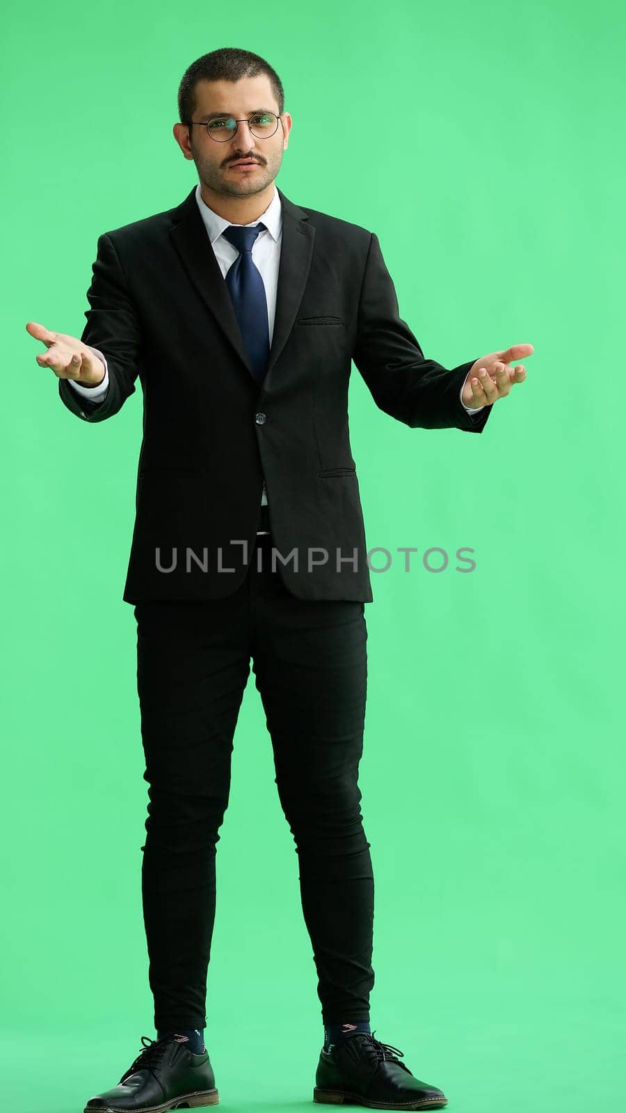 man isolated on a green background shows with his hands a sign of what to expect by Prosto