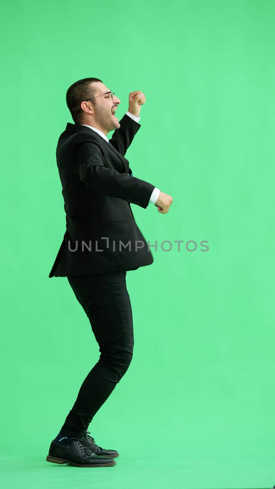 man in full growth. isolated on green background jumping rejoices.