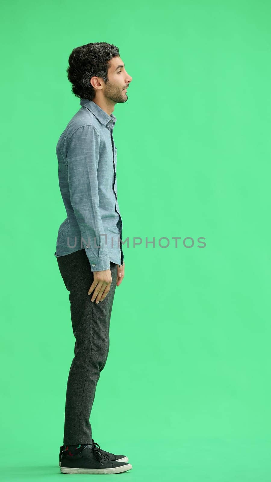 full-length portrait of a young man. standing isolated on green background by Prosto