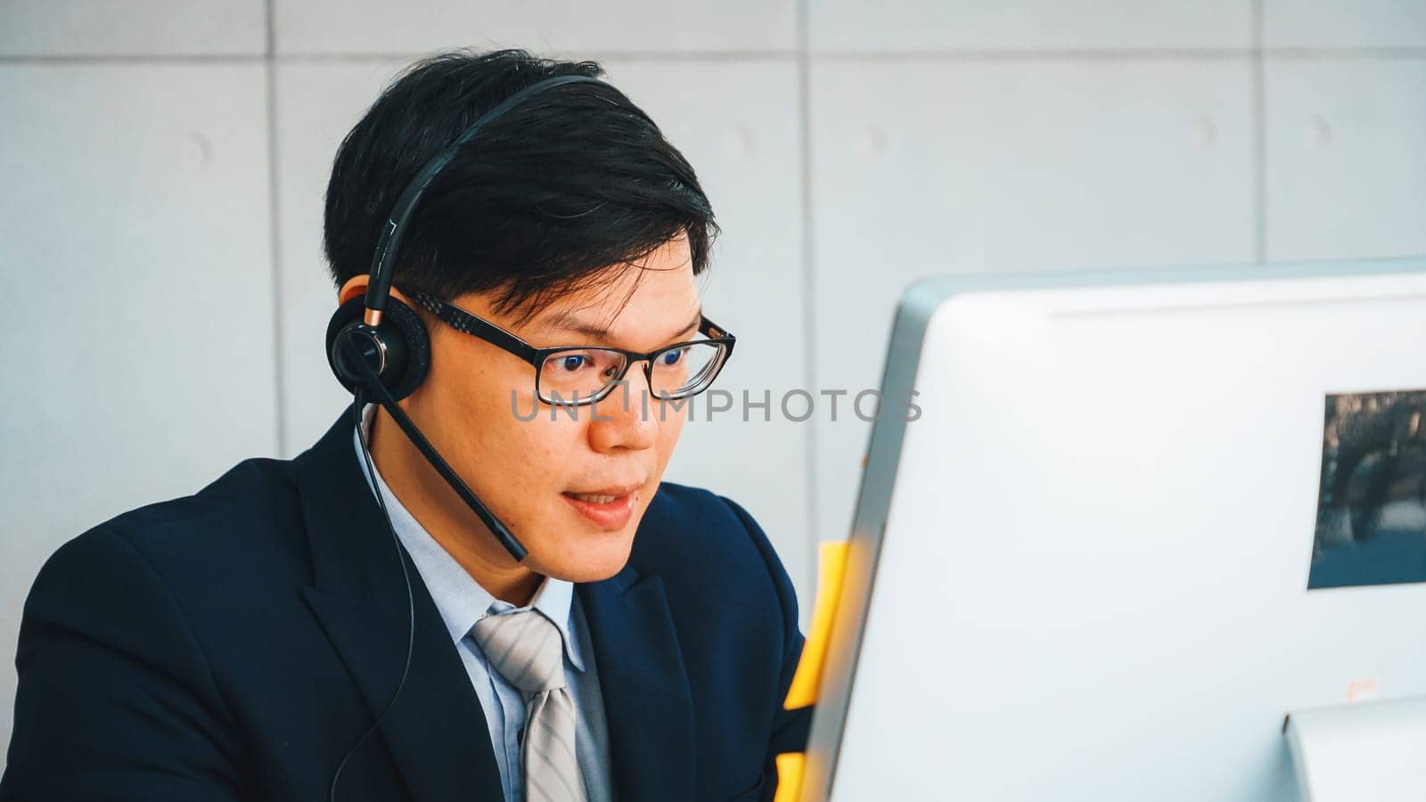 Business people wearing headset working in office to support remote customer or colleague. Call center, telemarketing, customer support agent provide service on telephone video conference call. Jivy