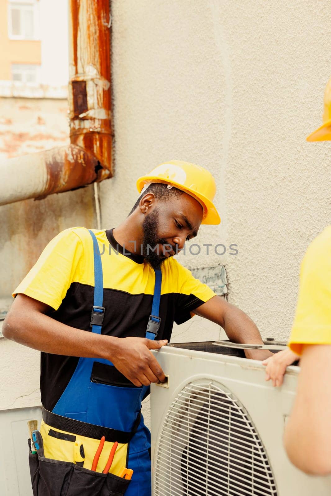 Repairmen disassembling air conditioner by DCStudio