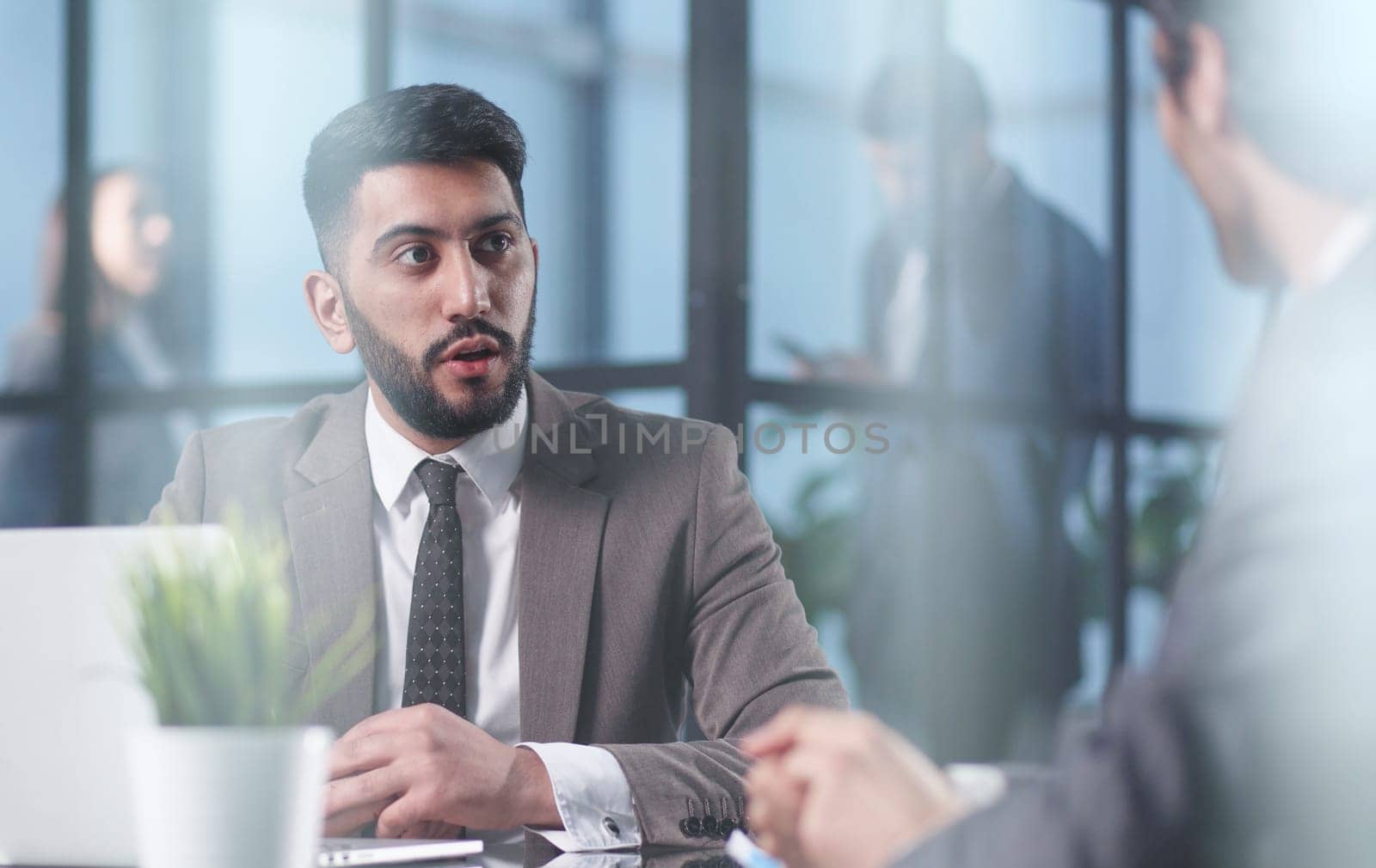 Two medium focused business workers communicate in the office.