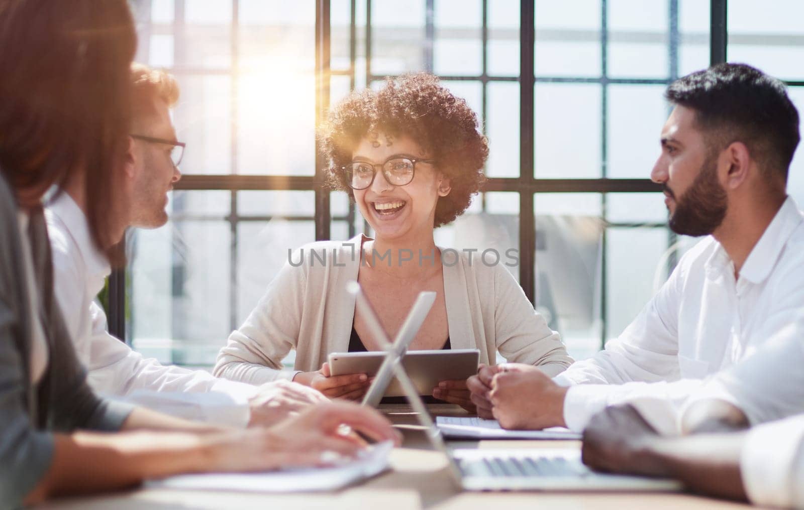 Happy young female employee discussing online project, showing computer presentation to skilled team leader in eyeglasses. Friendly diverse colleagues working in pairs on laptop, using applications.