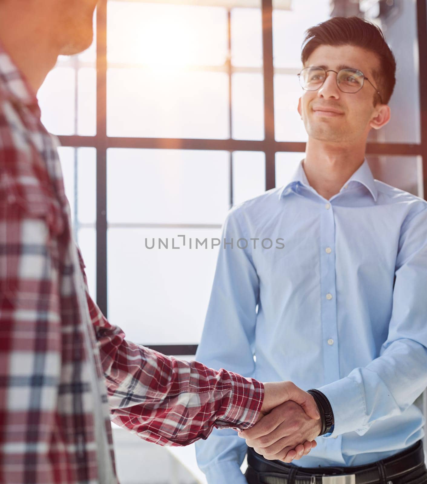 handshake between boss and employee in conference room by Prosto