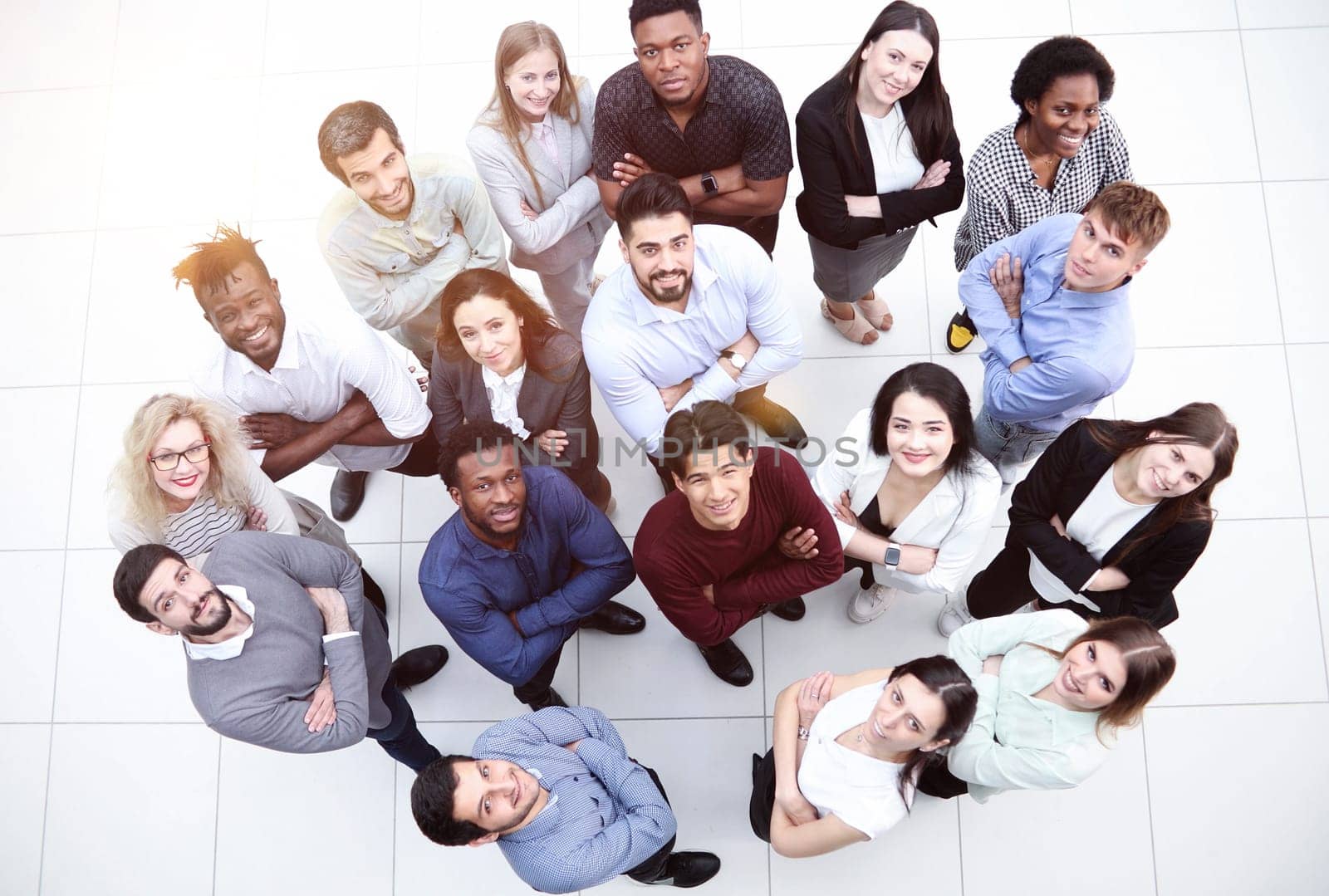 multicultural successful business group looking up in office corridor