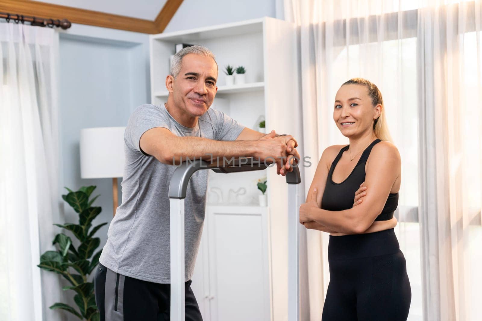 Athletic and sporty senior couple portrait in sportswear with standing posture as home exercise concept. Healthy fit body lifestyle after retirement. Clout