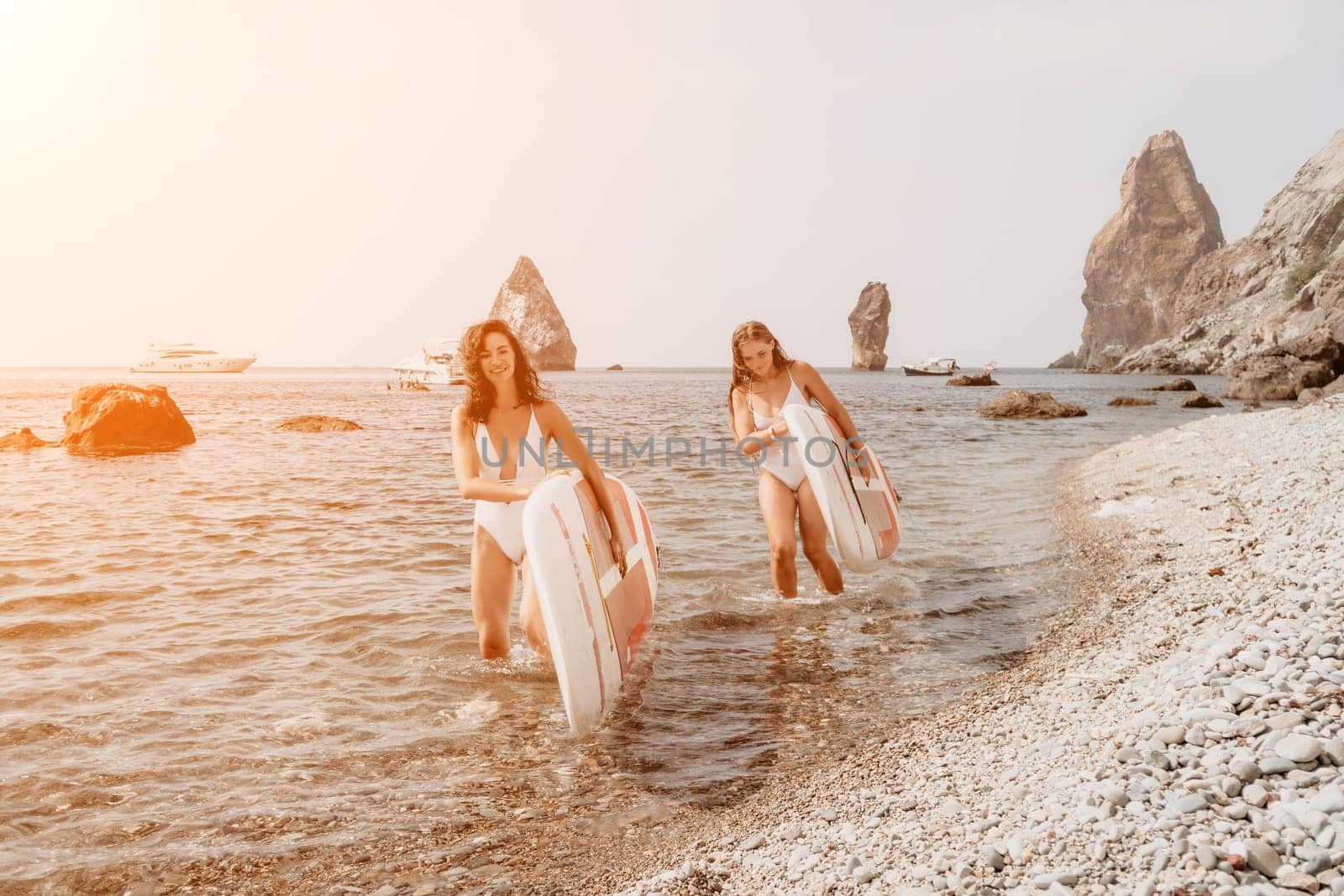 Woman sup yoga. Middle age sporty woman practising yoga pilates on paddle sup surfboard. Female stretching doing workout on sea water. Modern individual hipster outdoor summer sport activity