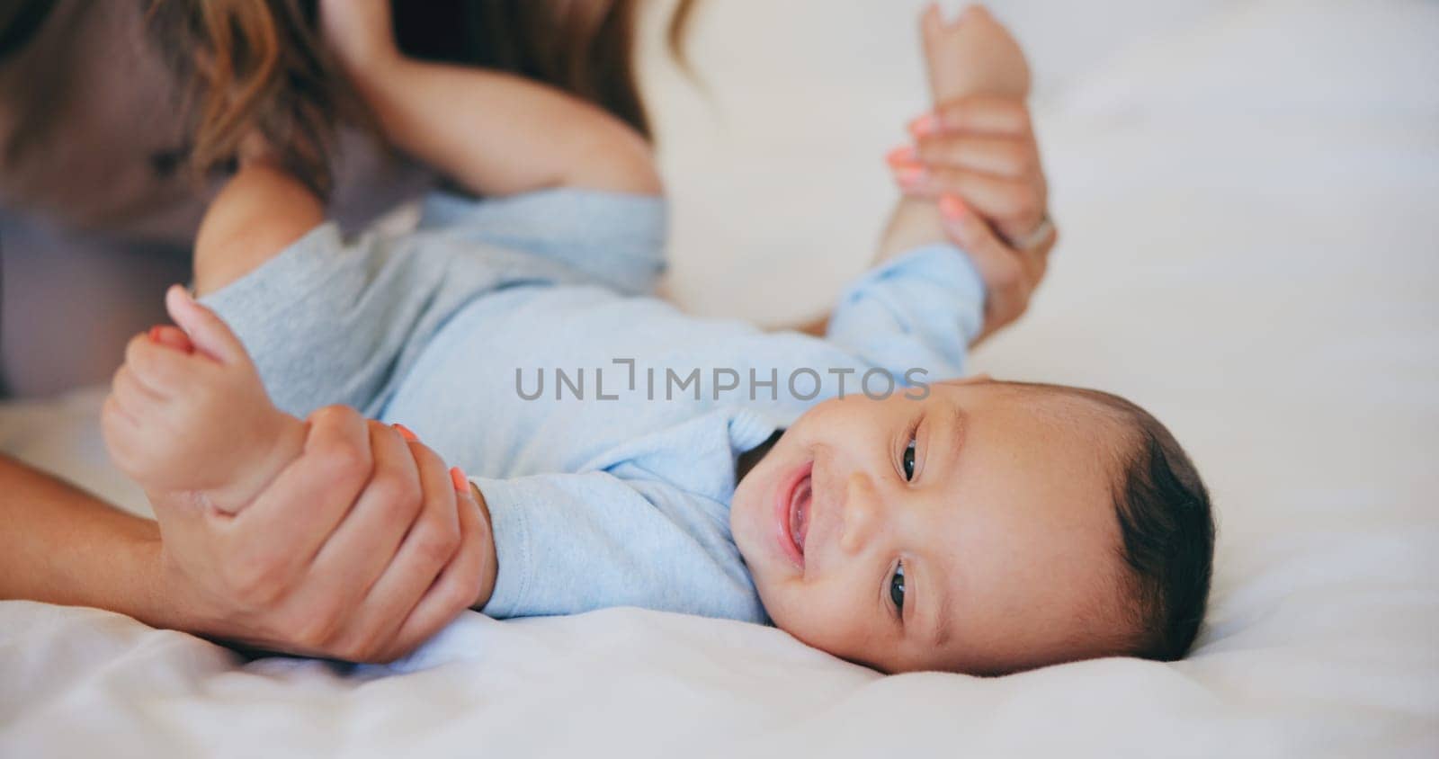 Hands, love and baby in bed with mother at home, play and bonding together, support or family trust. Child, mom and closeup of infant in bedroom, smile and security, care of toddler and growth of kid by YuriArcurs