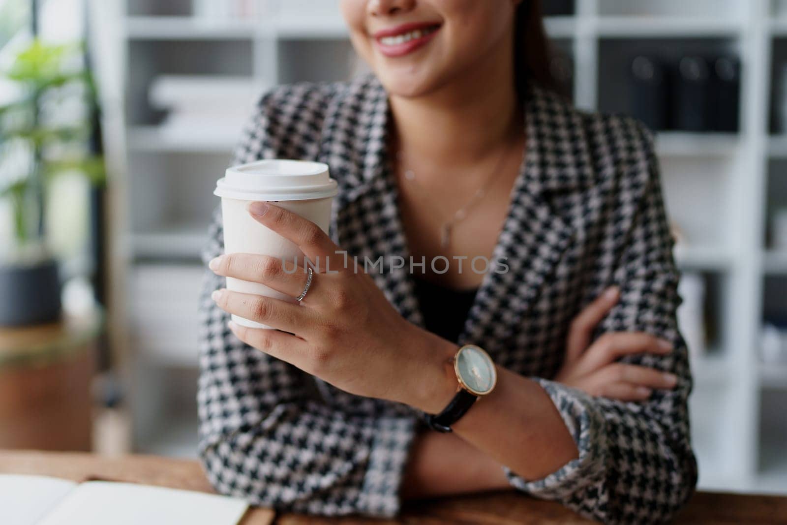 Portrait of a business woman talking on the phone and drinking coffee by Manastrong