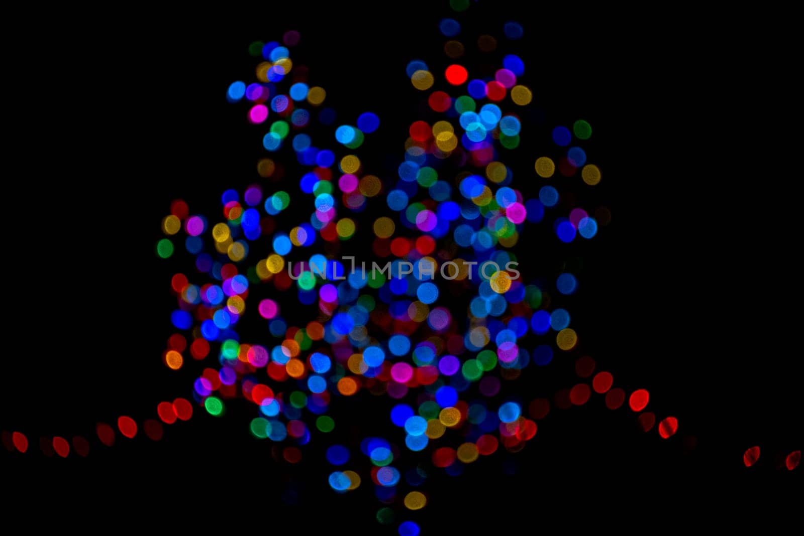 Colorful group of holiday lights on dark background of night