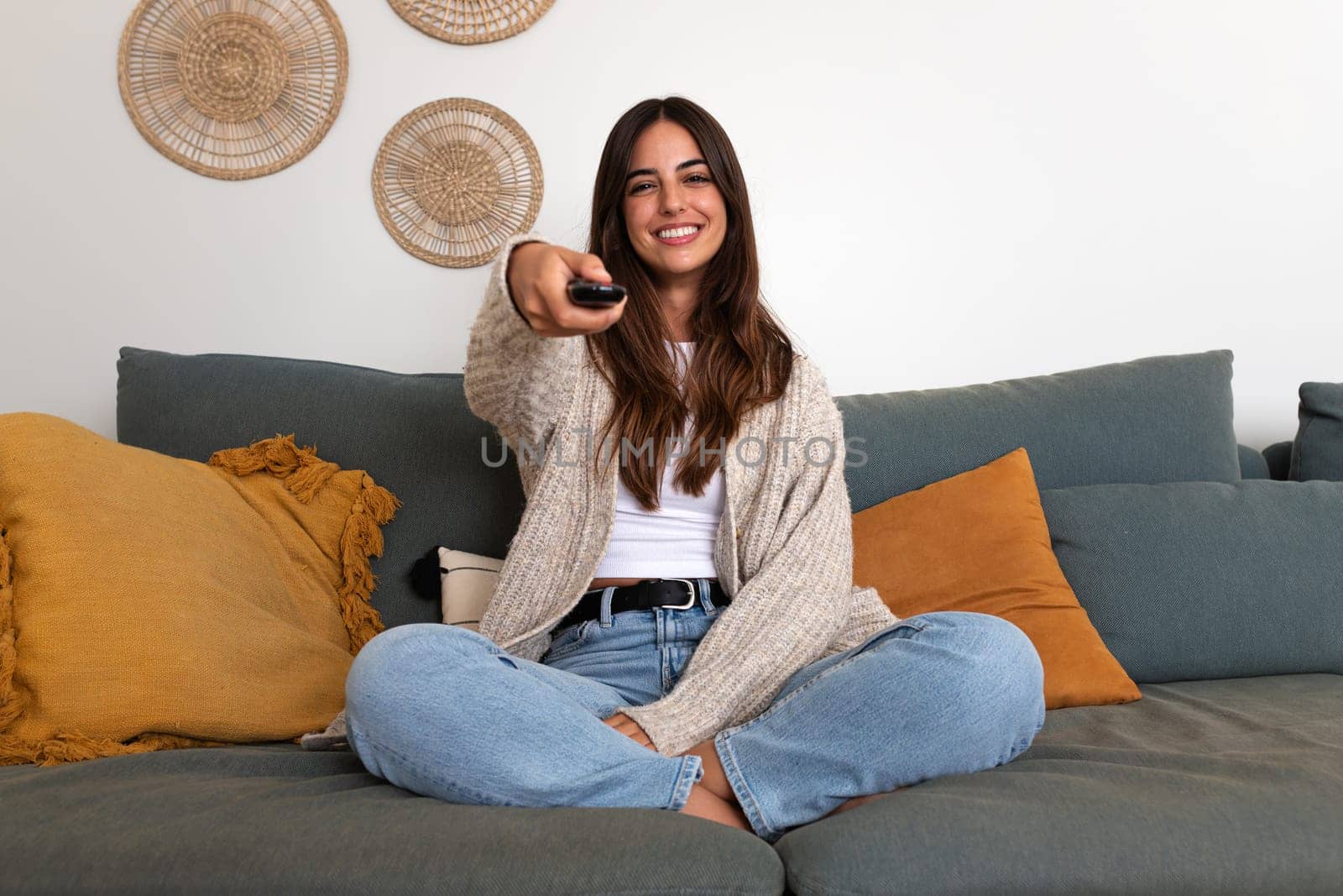 Happy caucasian woman watching TV sitting on the sofa relaxing. Lifestyle concept.