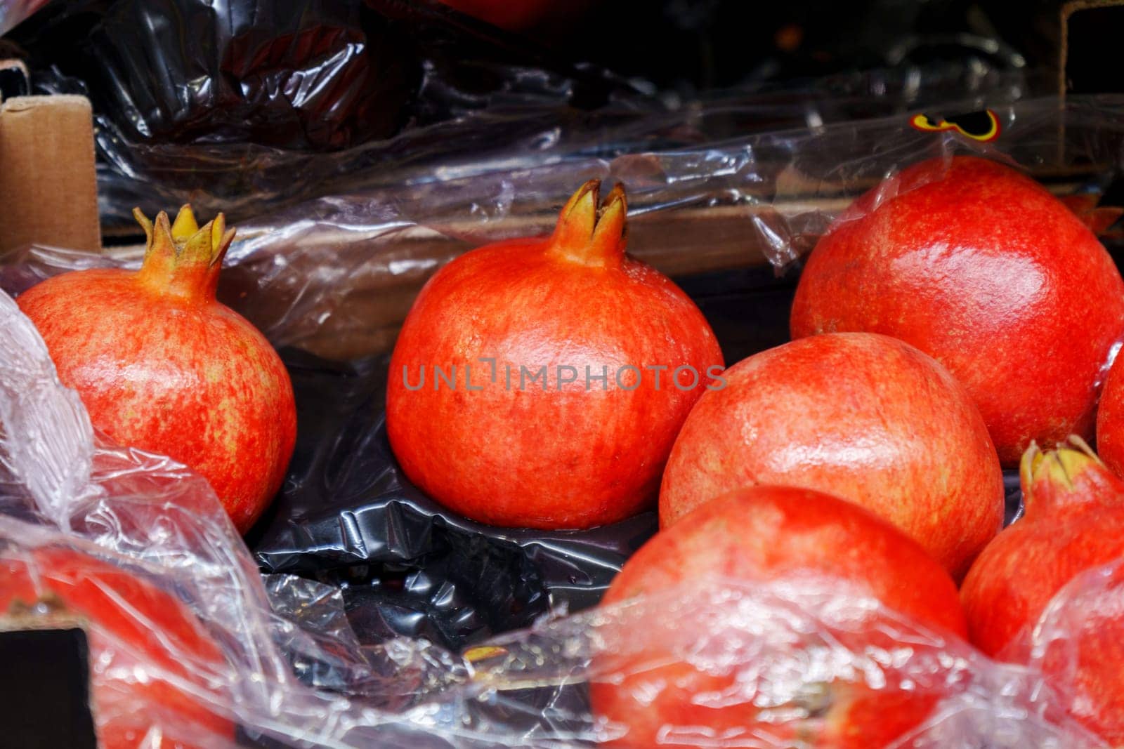 Pomegranates in the fruit department. Goods in the supermarket window. Buying fruit