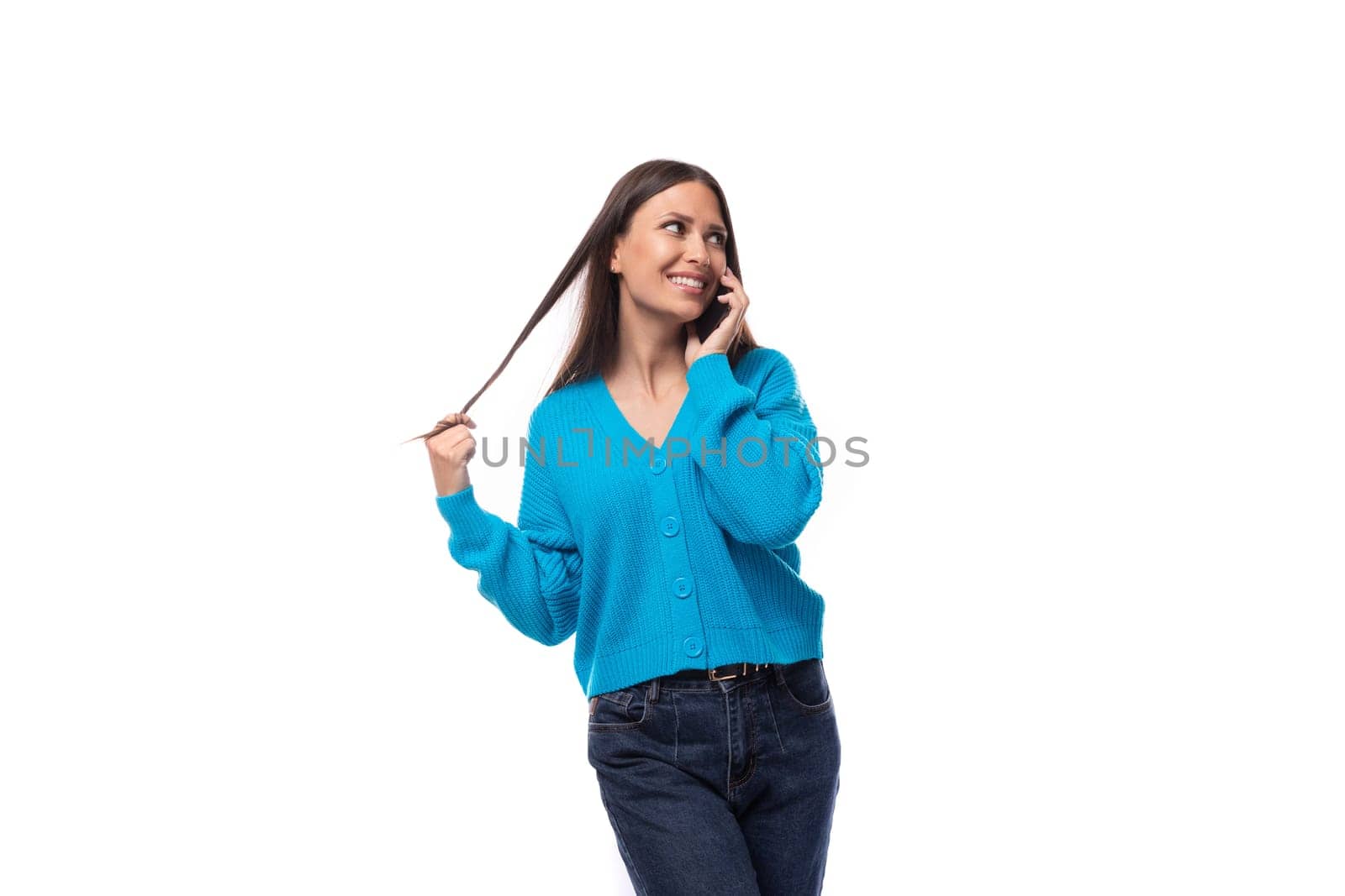 beautiful cute young woman dressed in a blue cardigan chatting on the phone.