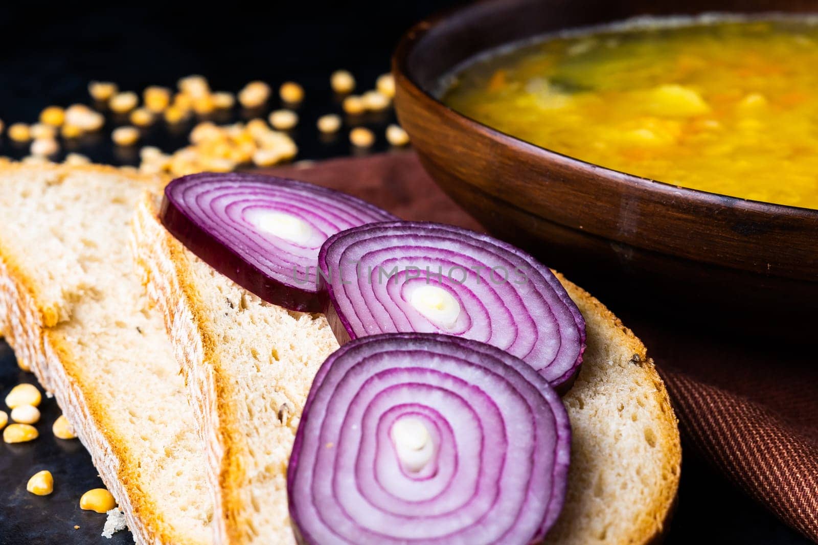 Appetizing hot pea soup and onion served with slices of bread by Zelenin