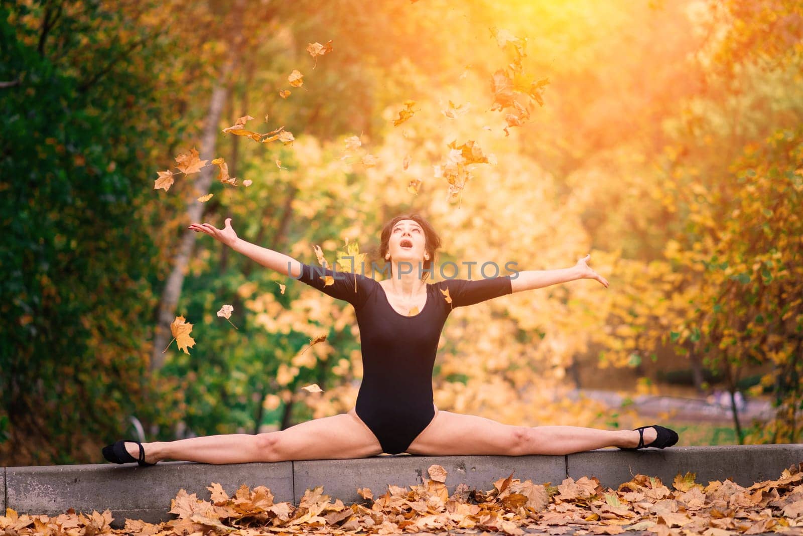 Beautiful female, ballerina, athlete in black bodysuit training in the park by Zelenin