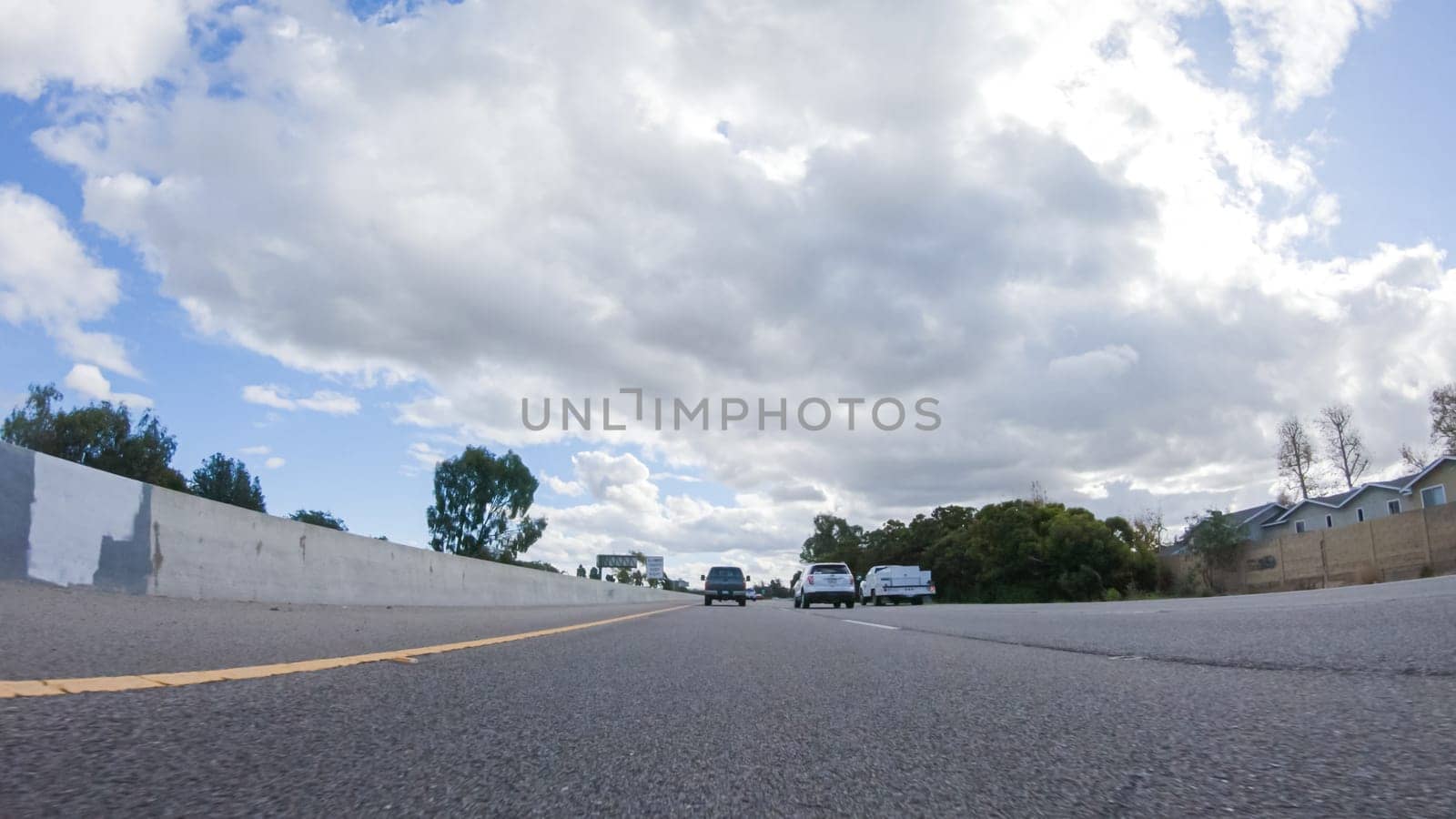 Santa Maria, California, USA-December 6, 2022-On a cloudy winter day, a car smoothly travels along Highway 101 near Santa Maria, California, under a cloudy sky, surrounded by a blend of greenery and golden hues.
